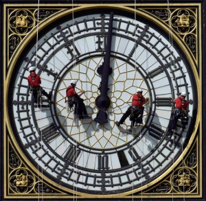 Cleaners abseil down one of the faces of Big Ben, to clean and polish the clock face, above the Houses of Parliament, in central London