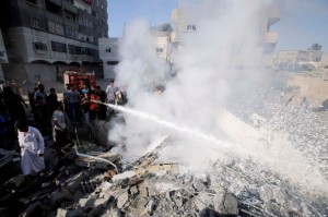 Palestinians help to put out a fire from the rubble of a house, which witnesses said was destroyed in an Israeli air strike, in Rafah in the southern Gaza Strip