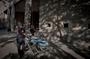 Paramedics wheel a gurney past the entrance of Mount Sinai Hospital in the Manhattan borough of New York